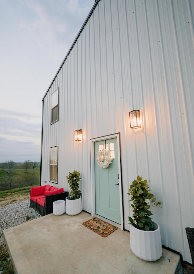 property entrance with a patio and board and batten siding