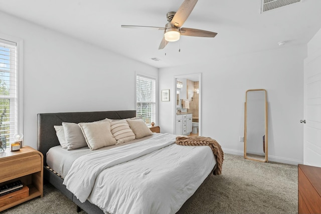 carpeted bedroom featuring visible vents, baseboards, ceiling fan, and ensuite bathroom