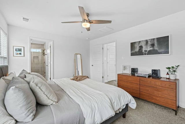 bedroom with baseboards, visible vents, light colored carpet, a ceiling fan, and ensuite bath
