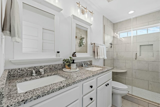 full bath with a stall shower, a sink, double vanity, and toilet