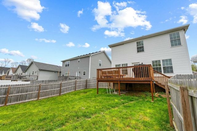 back of house featuring a wooden deck, a residential view, a lawn, and a fenced backyard