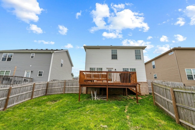 back of property with a yard, a deck, and a fenced backyard