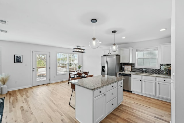 kitchen featuring a sink, recessed lighting, white cabinets, appliances with stainless steel finishes, and a kitchen island