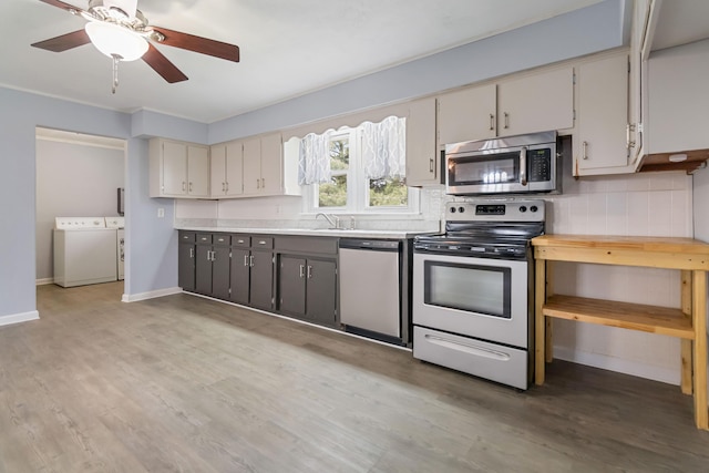 679 Mclain Rd, Springfield, KY 40069 - kitchen with washing machine and dryer, stainless steel appliances, light countertops, and light wood-style flooring