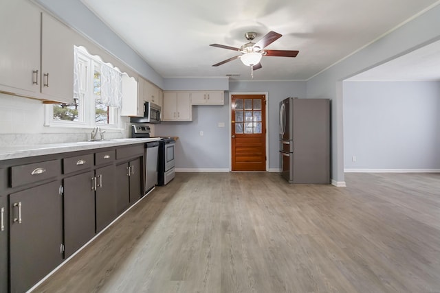 679 Mclain Rd, Springfield, KY 40069 - kitchen featuring a ceiling fan, light wood-style flooring, light countertops, baseboards, and appliances with stainless steel finishes