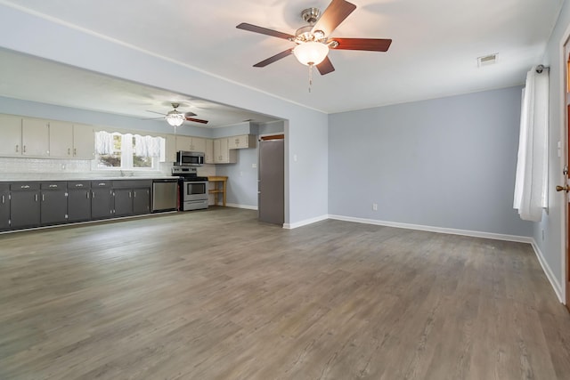 679 Mclain Rd, Springfield, KY 40069 - unfurnished living room featuring wood finished floors, visible vents, a ceiling fan, a sink, and baseboards