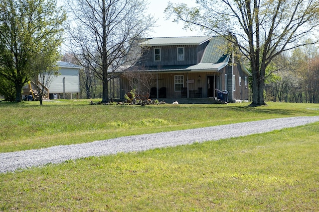view of front facade featuring a porch, metal roof, a gambrel roof, board and batten siding, and a front yard
