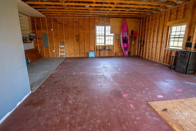 misc room featuring a garage, electric panel, and a wealth of natural light