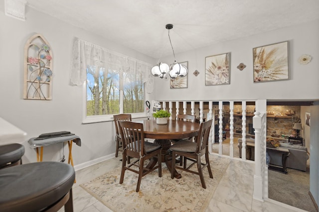 dining room featuring marble finish floor, baseboards, and a chandelier