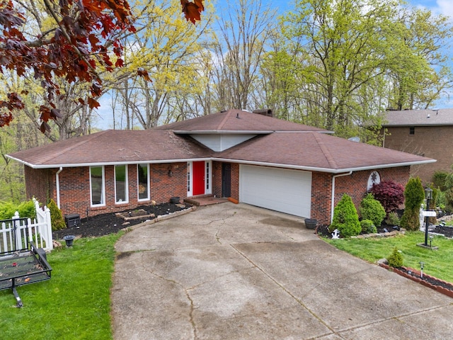 ranch-style house featuring brick siding, concrete driveway, a front lawn, a garage, and roof with shingles