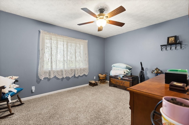 carpeted office featuring a ceiling fan, baseboards, and a textured ceiling
