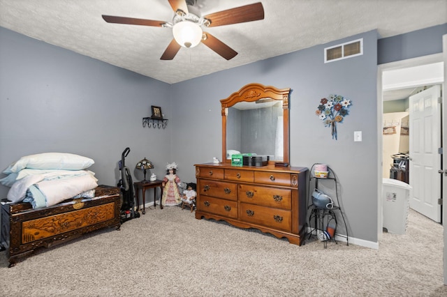 carpeted bedroom featuring baseboards, a ceiling fan, a textured ceiling, and visible vents