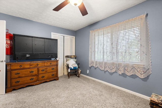 bedroom featuring baseboards, carpet floors, a closet, and ceiling fan