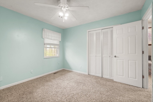 unfurnished bedroom featuring ceiling fan, baseboards, a closet, and carpet