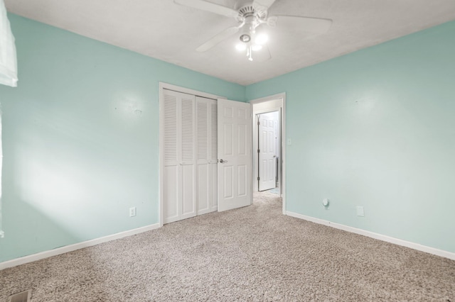 unfurnished bedroom featuring baseboards, carpet floors, ceiling fan, and a closet