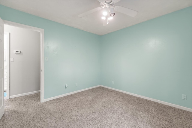 spare room with carpet floors, baseboards, and ceiling fan
