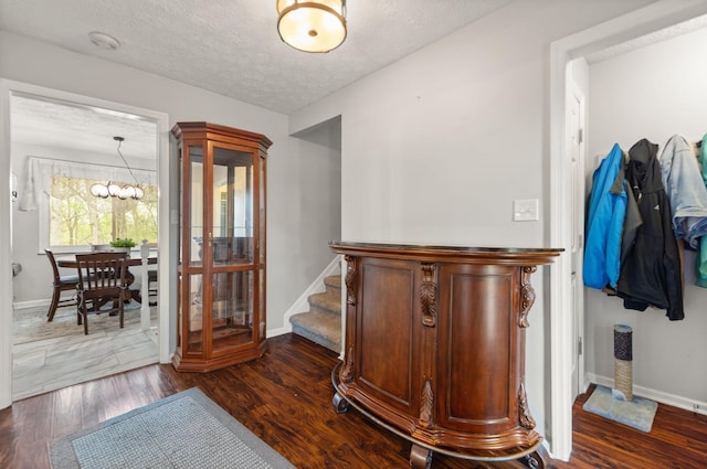 interior space featuring wood finished floors, a textured ceiling, and baseboards