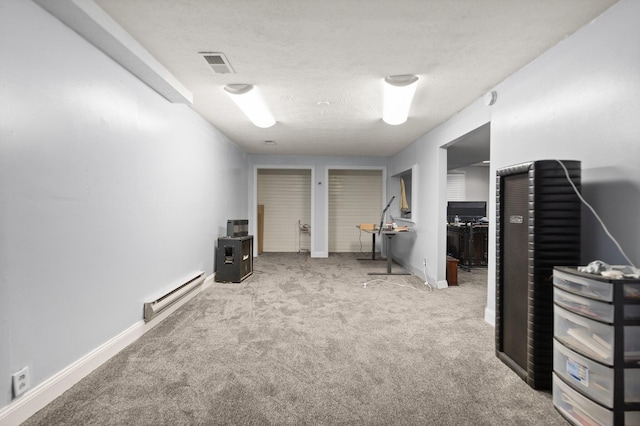 finished below grade area with baseboard heating, baseboards, carpet flooring, and visible vents
