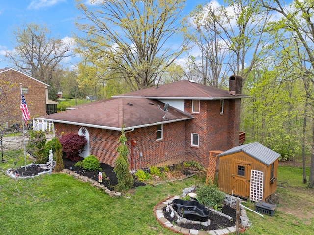 view of side of property with a storage shed, a chimney, a fire pit, a yard, and brick siding