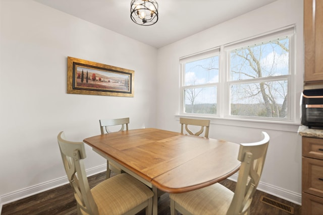 dining area featuring dark wood finished floors, baseboards, and visible vents