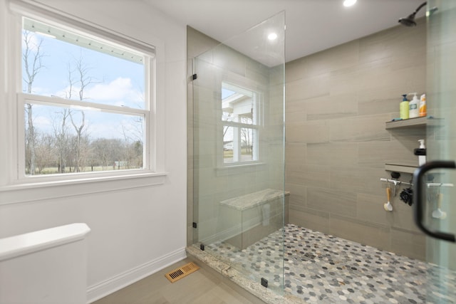 full bath featuring baseboards, a shower stall, and toilet