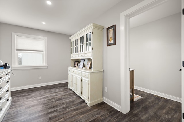 hall with baseboards, recessed lighting, and dark wood-type flooring