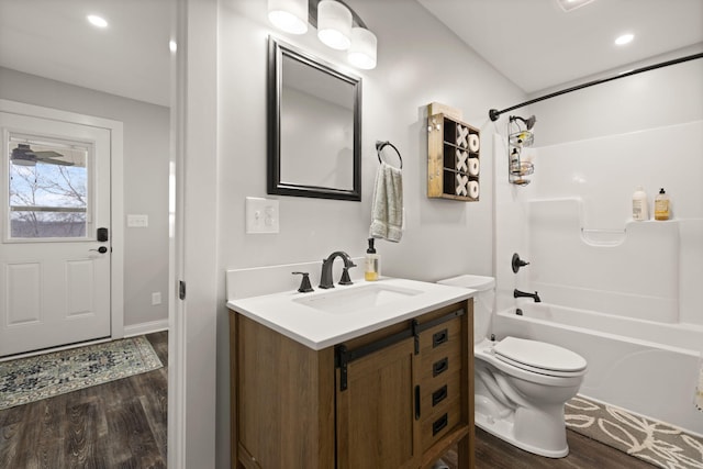 full bathroom with wood finished floors, shower / bathing tub combination, vanity, toilet, and recessed lighting