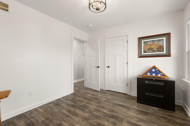 unfurnished bedroom with baseboards, visible vents, and dark wood-style floors
