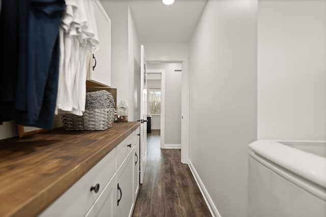 hall featuring baseboards and dark wood-style flooring