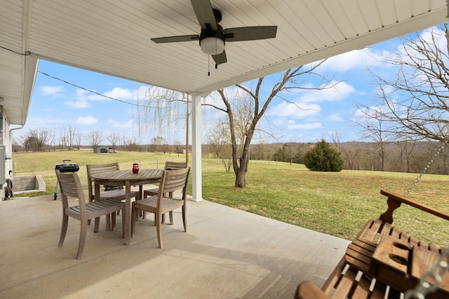 view of patio / terrace with a rural view, a ceiling fan, and outdoor dining space