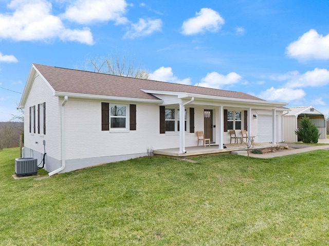 single story home with an attached garage, a front lawn, covered porch, and central AC