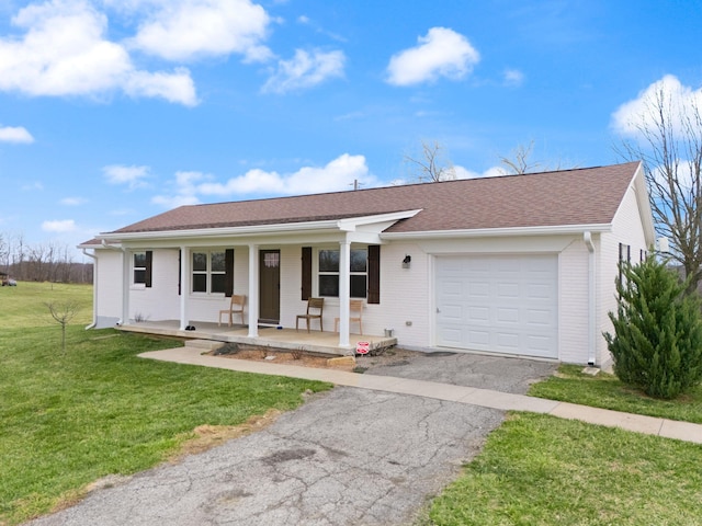 single story home with a front lawn, covered porch, brick siding, an attached garage, and aphalt driveway