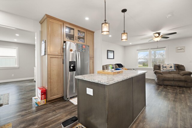 kitchen with open floor plan, dark wood finished floors, glass insert cabinets, and stainless steel fridge with ice dispenser