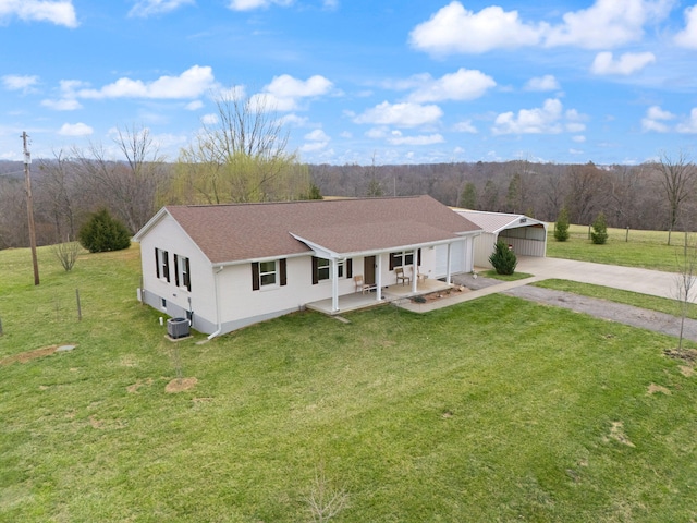 view of front of home featuring concrete driveway, a front lawn, a carport, and cooling unit