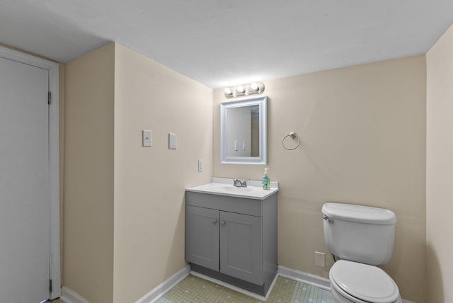 half bath featuring baseboards, toilet, and vanity