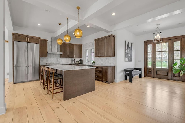 813 Westchester Dr, Lexington, KY 40502 - kitchen with beam ceiling, a notable chandelier, decorative backsplash, wall chimney range hood, and built in fridge