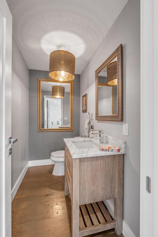 813 Westchester Dr, Lexington, KY 40502 - bathroom featuring toilet, vanity, wood finished floors, and baseboards