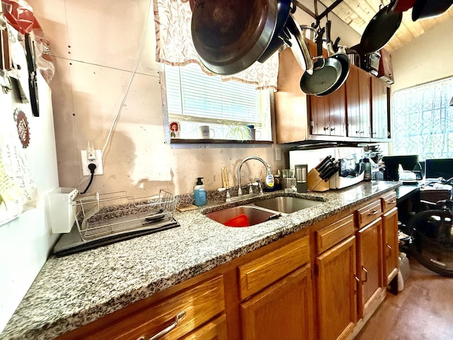 470 Cedar Bluff Rd, Monticello, KY 42633 - kitchen featuring brown cabinets, light stone countertops, and a sink
