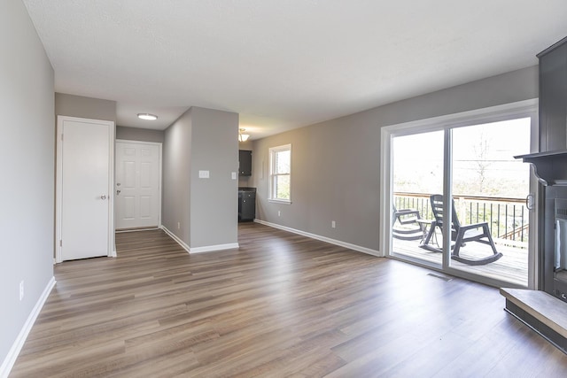 3241 Bowie Dr, Lexington, KY 40517 - unfurnished living room featuring visible vents, wood finished floors, and baseboards