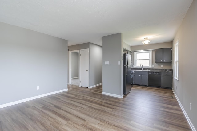 3241 Bowie Dr, Lexington, KY 40517 - kitchen with a sink, wood finished floors, black dishwasher, and freestanding refrigerator