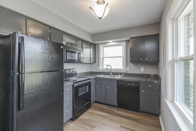 3241 Bowie Dr, Lexington, KY 40517 - kitchen featuring light wood finished floors, dark countertops, a healthy amount of sunlight, a sink, and black appliances