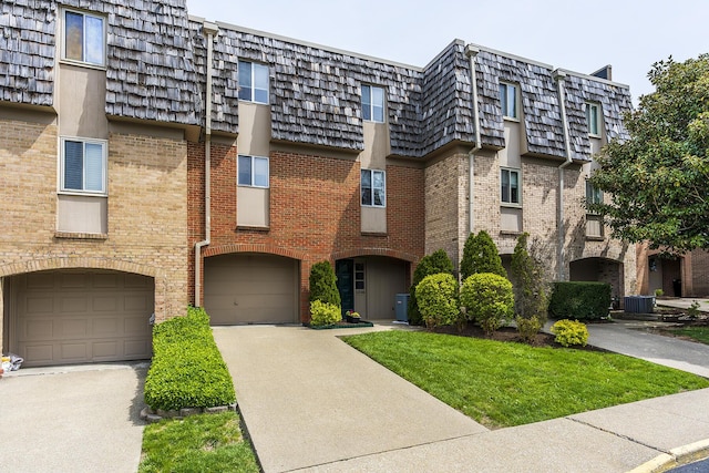 view of building exterior featuring central AC, driveway, and a garage