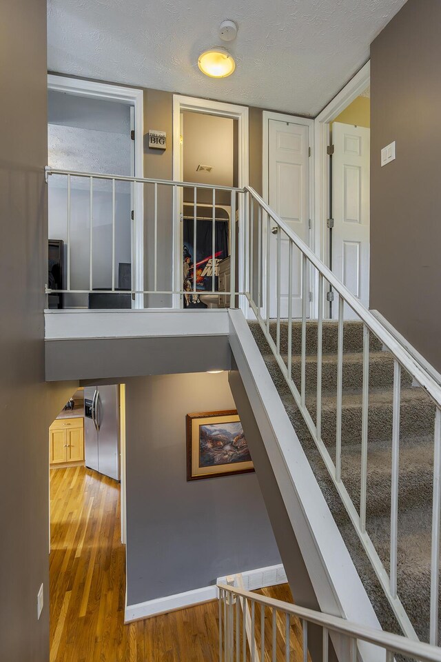 staircase with wood finished floors and baseboards