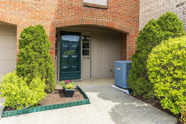 entrance to property featuring central air condition unit and brick siding