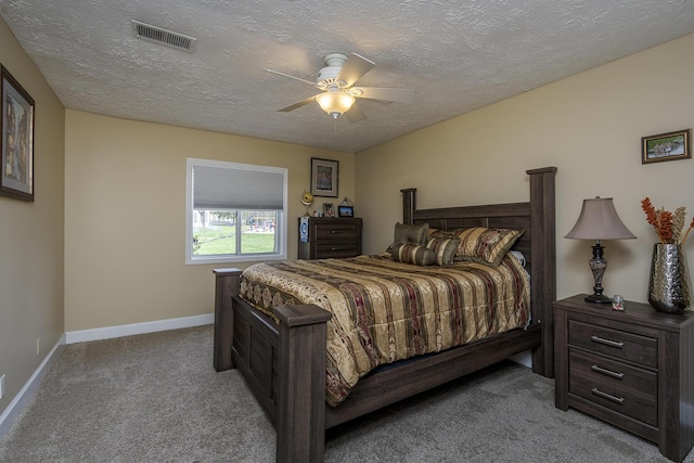 carpeted bedroom with a textured ceiling, visible vents, baseboards, and ceiling fan