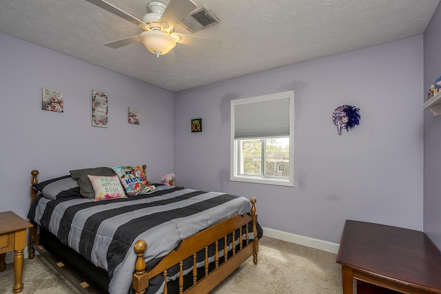 carpeted bedroom featuring a textured ceiling, visible vents, a ceiling fan, and baseboards