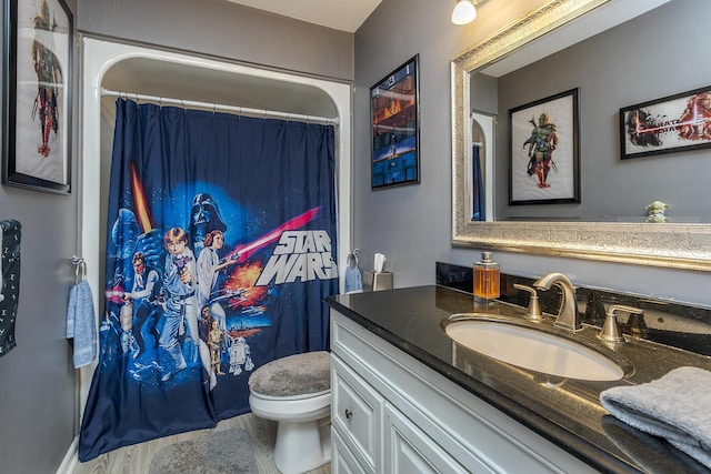 bathroom featuring wood finished floors, vanity, a shower with shower curtain, and toilet