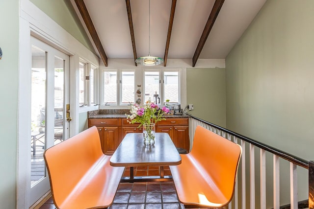 dining room featuring vaulted ceiling with beams
