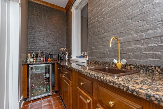 bar with wine cooler, a sink, brick wall, tile patterned flooring, and indoor wet bar