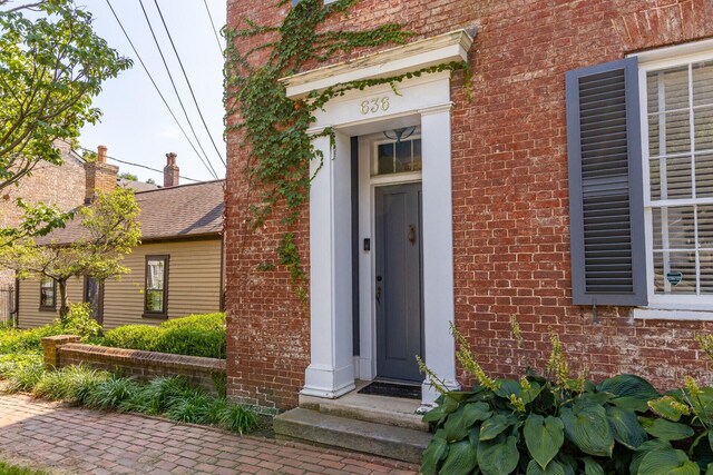 doorway to property featuring brick siding